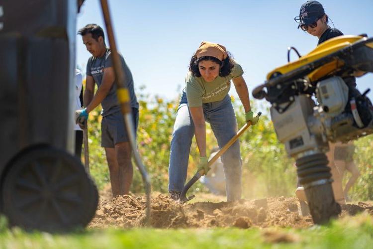 A student helps an area nonprofit with landscaping during the university's Day of Service held during Week of Welcome. 